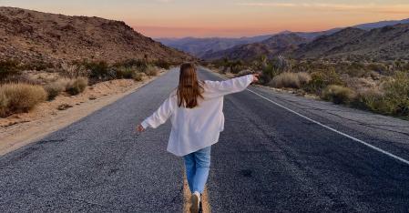 Il processo di assegnazione Una ragazza alla pari corre a braccia aperte lungo l'autostrada nel deserto